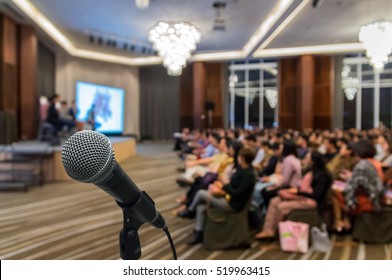 Microphone over the Abstract blurred photo of conference hall or seminar room with attendee background, Business meeting concept - Shutterstock ID 519963415