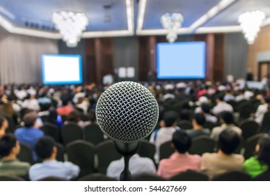 Microphone Over The Abstract Blurred Photo Of Conference Hall Or Seminar Room With Attendee Background, Business Meeting Concept