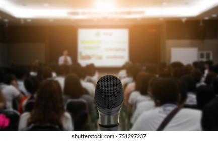 Microphone Over The Abstract Blurred Photo Of Conference Hall Or Seminar Room With Attendee Background,Small Business Training Concept,Public Speaking Using As Background And Wallpaper.