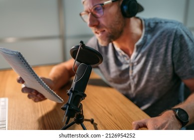 Microphone with pop filter closeup photo with blogger man in headphones recording voice or making online webinar or news announcement. Modern home sound studio audio recording technology concept. - Powered by Shutterstock