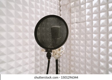 Microphone With Pop Filter On Mic Stand In Soundproof Isolation Booth For Vocal Recording At Sound Studio