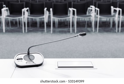 Microphone In Press Conference Room With Empty Seats In The Background