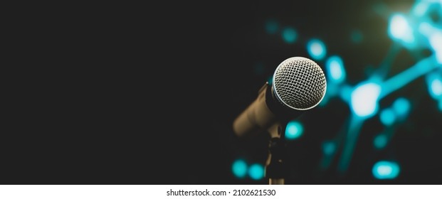 Microphone Public Speaking Background, Close Up Microphone On Stand For Speaker Speech Presentation Stage Performance With Blur And Bokeh Light Background.