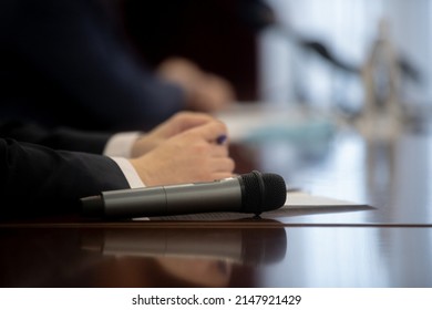 Microphone In Seminar Room, Conference Event Or Press Conference Abstract Blurred Background. News Conference. Political Debate During Answering Media Questions. 