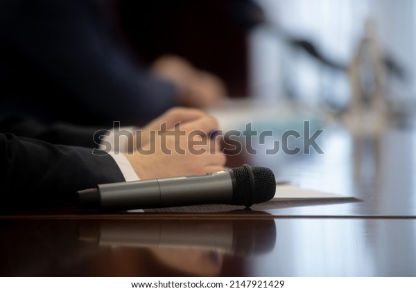 Microphone in seminar room,\
conference event or press conference Abstract blurred background.\
News conference. Political debate during answering media questions.\
