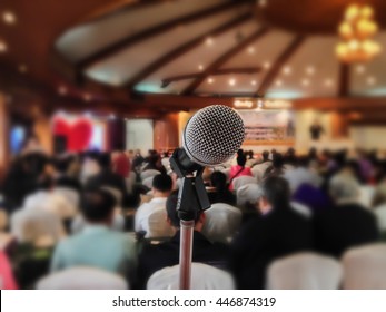 Microphone set up on blurred people in seminar event hall