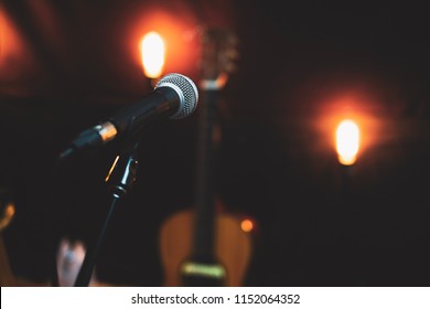 Microphone In Studio Against The Background Of Acoustic Guitar And Vintage Lighting