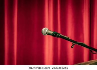 microphone in a theater with a red curtain in the background - Powered by Shutterstock