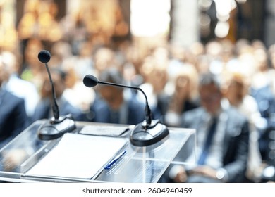 Microphones in focus, unrecognizable people in background at business conference, corporate presentation, workshop, coaching training, news conference, company meeting, public or political event