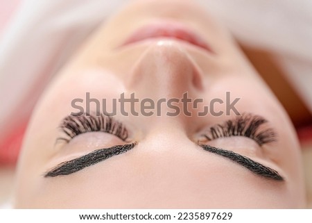 Micropigmentation eyebrows work flow in a beauty salon. Woman having her eye brows drawn and tinted. Semi-permanent makeup for eyebrows. Focus on eyebrow.Horizontal Orientation