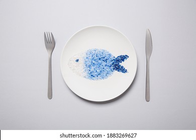 Microplastic fish on a white plate with place setting