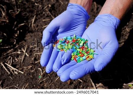 Microplastic pollution. Microplastics in ground. Soil contaminated with microplastics. Plastic waste in soil, earth. Environmental, groundwater disaster. Plastic waste in ground at agricultural field.