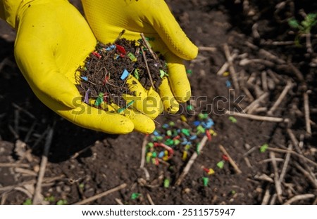 Microplastic pollution. Microplastics in ground. Soil contaminated with microplastics. Plastic waste in soil, earth. Environmental, groundwater disaster. Plastic waste in ground at agricultural field.
