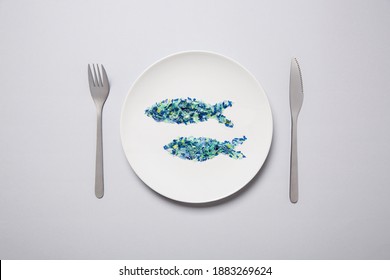 Microplastic sardines on a white plate with place setting