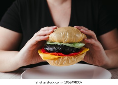 Microplastic In Water And Food. Woman Eating Artificial Food Products Made Of Plastic Bags. Human Health, Nutrition And Environmental Pollution