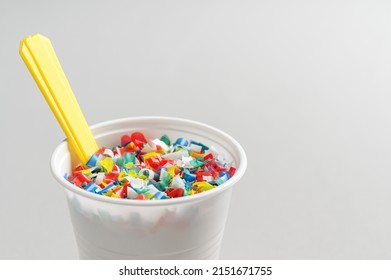 Microplastic In White Plastic Cup With Spoon. Light Grey Background. Microplastic Problem Concept. Place For Text