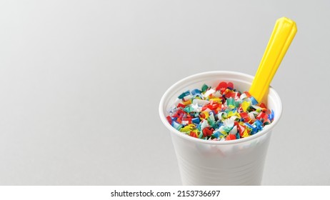 Microplastic In White Plastic Cup With Spoon. Light Grey Background. Microplastic Problem Concept. Place For Text