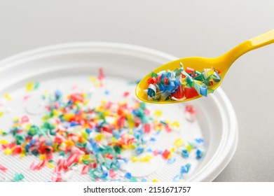 Microplastic In White Plastic Dish With Spoon. Light Grey Background. Microplastic Problem Concept. Close Up