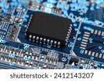 A microprocessor on a printed circuit board surrounded by auxiliary elements, backlit through the board. Macrofto in dark colors