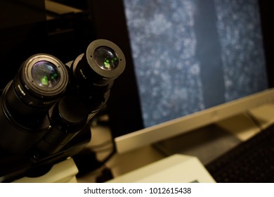 A microscope with a grey cell image in the background