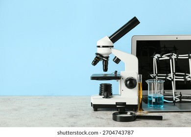 Microscope with laptop, molecular model and flasks of samples on blue background. Nobel Prize Day