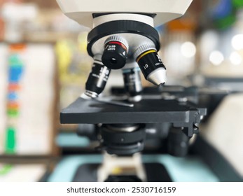 microscope, microscope's objective lenses, clearly displaying the different magnifications labeled 10x, 40x, and 100x, laboratory equipment, scientific research, biology, microscopy