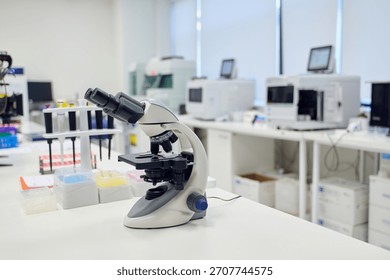 Microscope on lab counter surrounded by scientific equipment in a modern laboratory setting