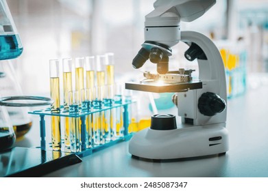 microscope is on a table with a bunch of test tubes. The tubes are yellow and blue