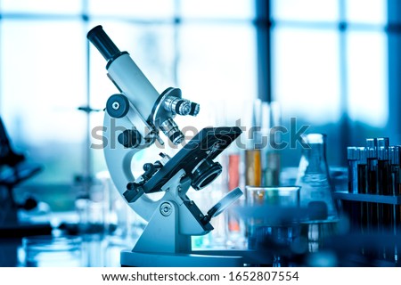 Microscope on the table with chemical tube and glassware in laboratory, Science research technology