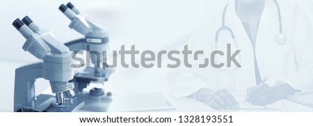 Microscope over doctor hands background.