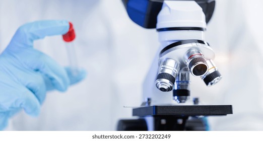 Microscope and scientist in laboratory setting with test tube, banner.