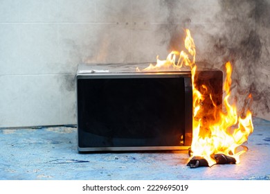 microwave oven on fire. the concept of fire in the kitchen and malfunctions, breakdowns of electrical appliances and wiring, installation of fire safety systems. - Shutterstock ID 2229695019