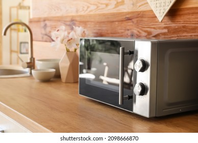 Microwave Oven On Wooden Tabletop In Kitchen