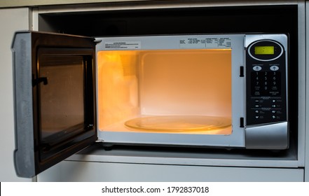 Microwave Oven With An Open Door And A Light On.