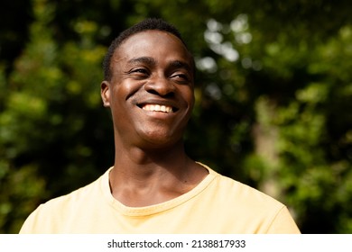Mid Adult African American Man Smiling While Looking Away Against Plants. Unaltered, Lifestyle, Copy Space And Contented Emotion.