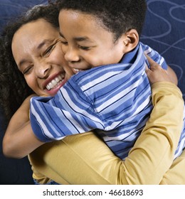 A Mid Adult African American Woman Affectionately Hugs Her Young Son. Square Shot.