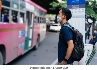 Mid Adult Asian Man Wearing Protective Face Covering, Waiting To Catch A Bus During The Pandemic, On The Move, Passenger, Safety