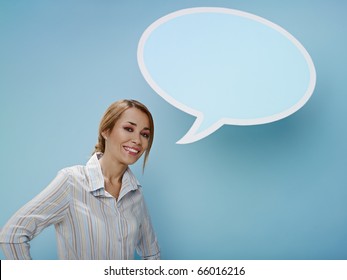 mid adult business woman standing near blank speech bubble on blue background. Horizontal shape, front view, waist up, copy space - Powered by Shutterstock