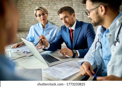 Mid adult businessman and group of doctors working on a computer during a meeting. - Shutterstock ID 1773233825