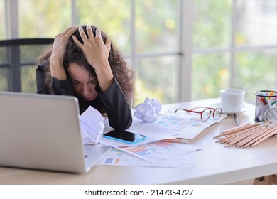 Mid adult businesswoman lying face down on table in office after bad news business failure or get fired and feeling discouraged, distraught, distraught and hopeless in modern office. 