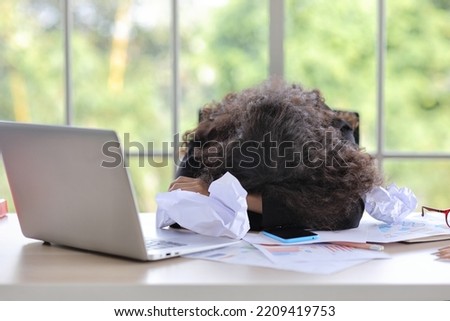 Mid adult businesswoman lying face down on table in office after bad news business failure or get fired and feeling discouraged, distraught, distraught and hopeless in modern office. 