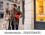 A mid adult Caucasian couple walks cheerfully on a city street on Valentine