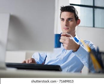 Mid Adult Caucasian Male Business Man Looking At Computer Screen And Holding Blue Coffee Cup. Horizontal Shape, Waist Up, Front View