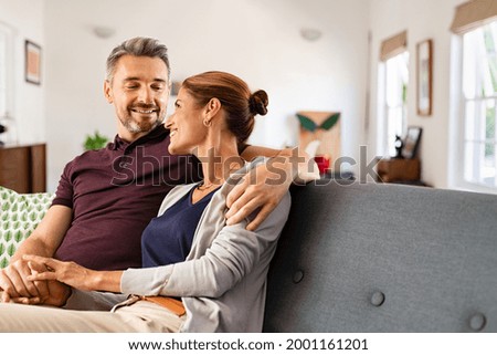 Similar – Image, Stock Photo A middle-aged couple hugging each other and observing a sunset sea, we see them from the back