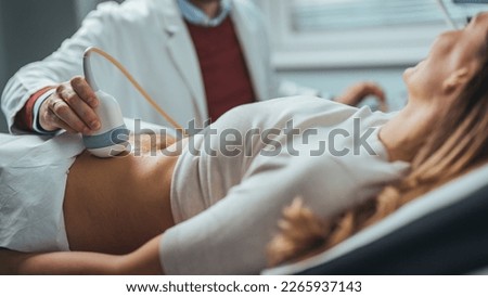 Mid adult male doctor using ultrasound scanner. Ultrasound exam. Doctor's hands on a woman's stomach, ultrasound of the abdominal cavity, close-up. Diagnosis of diseases of the genitourinary system