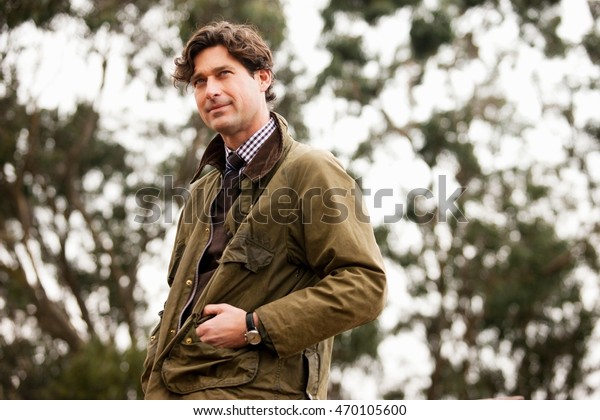 Mid adult man in\
countryside, looking away