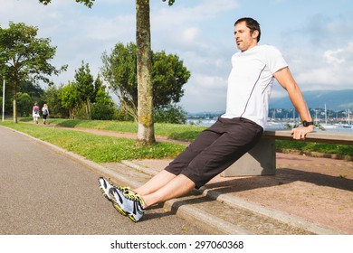 Mid Adult Man Doing Pushups Outdoors Using A Bench