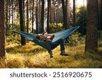 Mid adult man relaxing on hammock in the forest