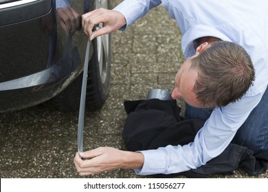 Mid Adult Man Using Duct Tape To Fix His Car. Horizontal Shot.