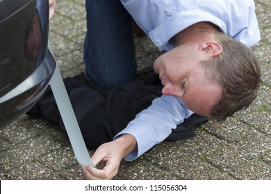 Mid Adult Man Using Duct Tape To Fix His Car. Horizontal Shot.